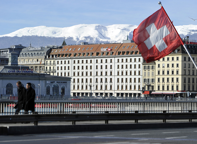 GENEVA, SWITZERLAND - FEBRUARY 09:  A Swiss flag flies above a HSBC logo is seen on HSBC offices on February 9, 2015 in Geneva, Switzerland.  It has been discovered that the HSBC bank has helped wealthy clients to evade tax in several countries across the world, including the UK, America, France and Belgium. (Photo by Harold Cunningham/Getty Images)